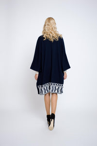 Knitted merino wool cape with geometric border